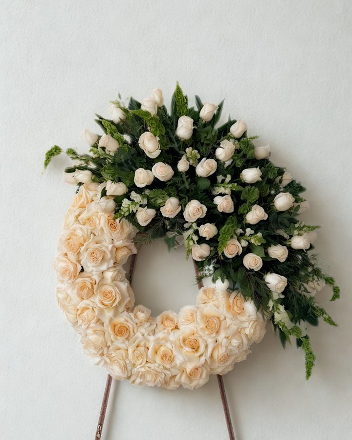 A cream rose wreath on a stand